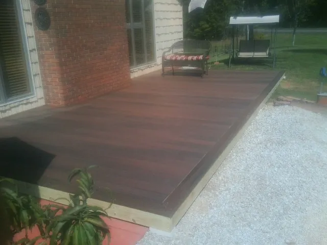 Freshly stained wood deck built against a brick home in Lancaster